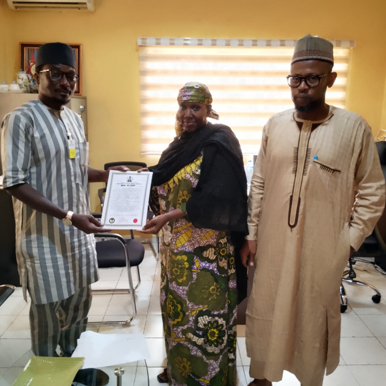 Acting Executive Director, NIWRMC, Mrs. Sakinatu Suleiman Abbo Jimeta (M) making presentation of the Water Use Licence to Rabiu Maska, the Social Performance Specialist, BUA Cement (L), flanked by the Director, Allocation and Authorization, Engr. Shazali Uba Ajingi (R) in Abuja